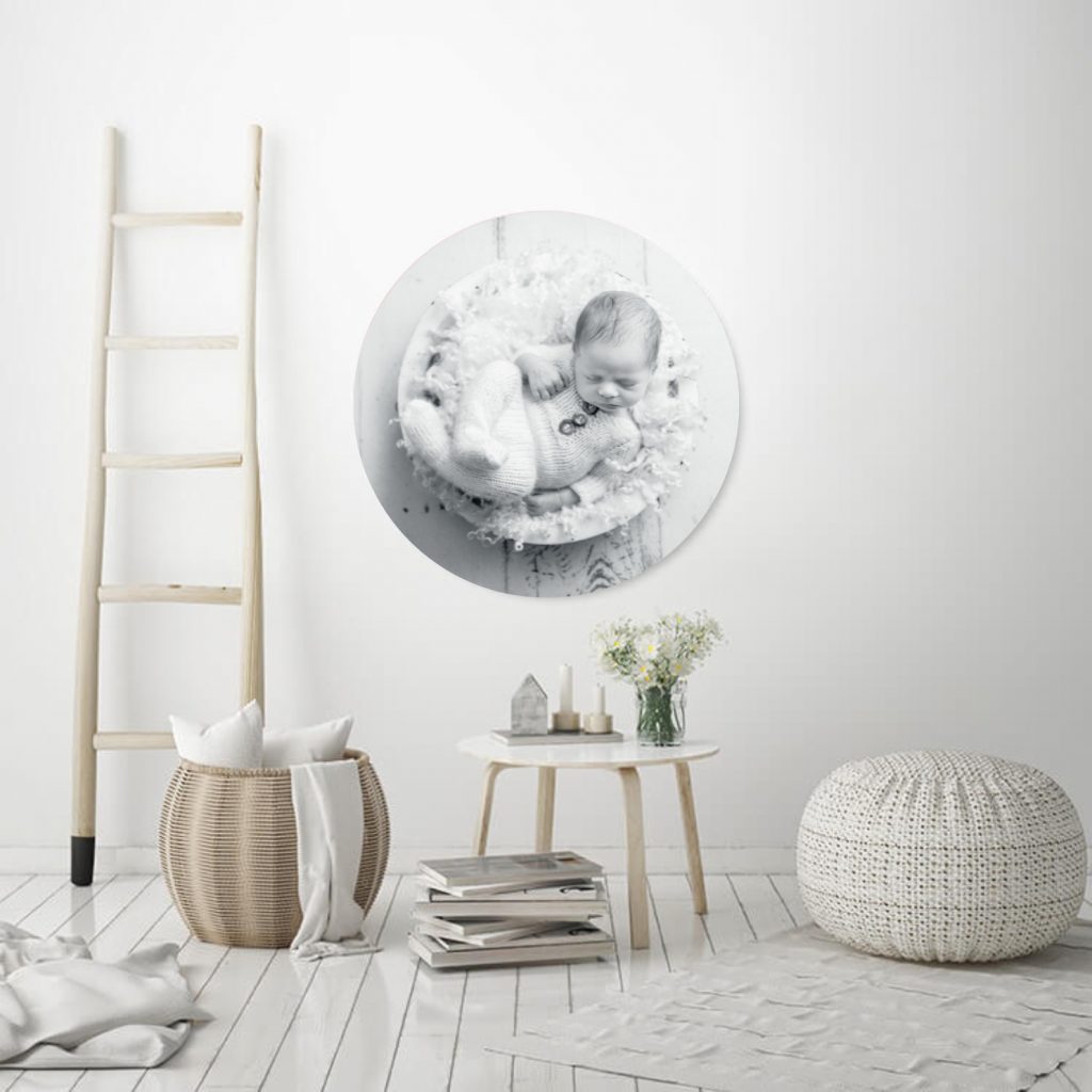 Black and white Newborn Baby portrait wall art shown in an acrylic sphere hanging on the wall set in a clean white room or nursery by Horsham  Photographer